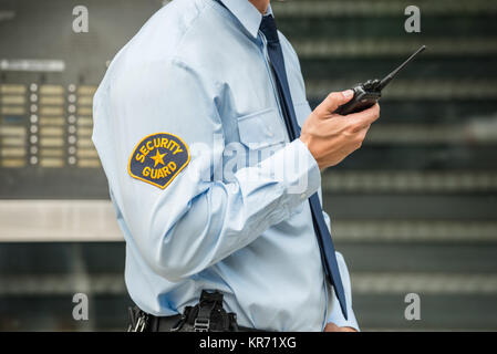 La guardia di sicurezza utilizzando un walkie-talkie Foto Stock