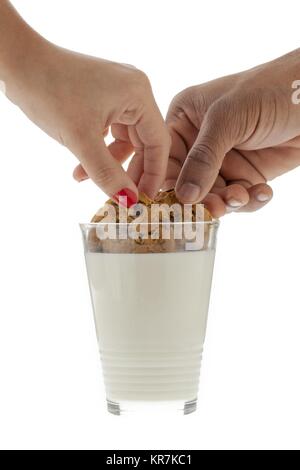 Due persone dipping cookies nel latte Foto Stock