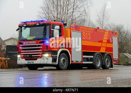 SALO, Finlandia - 16 febbraio 2014: Scania P360 motore Fire con luci lampeggianti al fuoco scena di Salo impianto per cemento. L'impianto è stato completamente destr Foto Stock