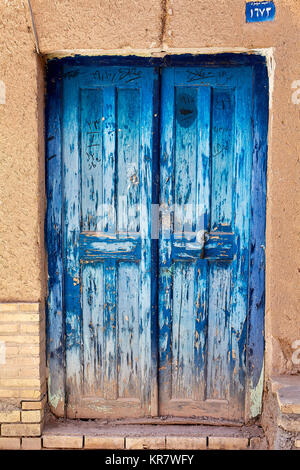 Vecchio vintage danneggiato chiuso lo sportello blu in casa di argilla, Yazd, Iran. Foto Stock