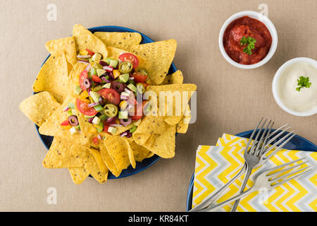 Vegetariano nachos con salsa e panna acida salse Foto Stock