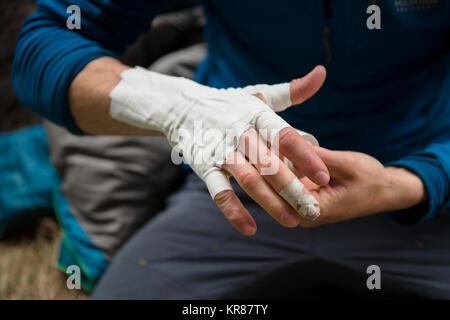 Stretta di mano essendo fissati con nastro in preparazione per la scalata di un percorso crack Foto Stock