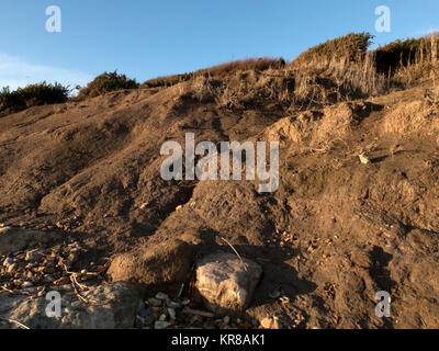 Prove di cliff ed erosione costiera, perdita di edifici ed esposto le tubature, sistemi di drenaggio, argilla morbida, fango e scogliere collassata. Foto Stock