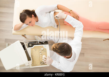 Medico maschio utilizzando Sonogram sul paziente femmina Foto Stock