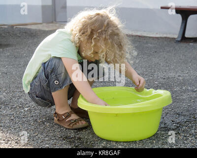 Ragazzo giocando con acqua in cantiere Foto Stock