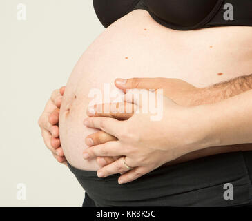 Donna incinta tenendo le sue mani sulla pancia bella Foto Stock