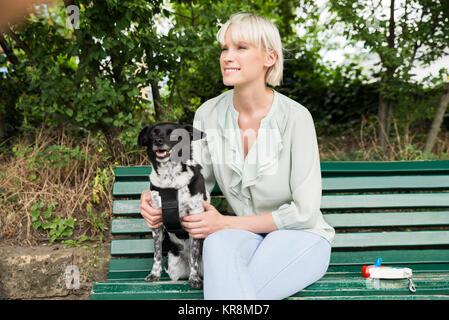 Donna felice con il suo cane sul banco di lavoro Foto Stock