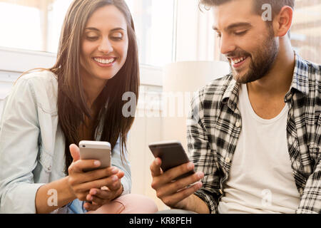 Gli amici inviando un messaggio di testo Foto Stock