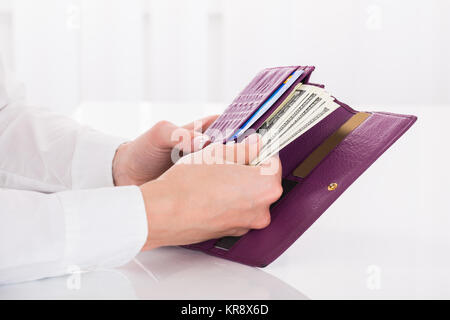 La femmina mano che tiene il borsellino con banconote Foto Stock