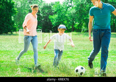 Famiglia giocando con il pallone da calcio Foto Stock