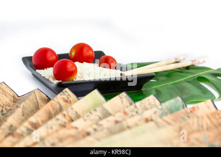 Set orientali di riso, pomodori, bastoncini, foglie verde e trasp Foto Stock