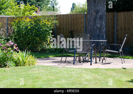 Patio con tavolo e sedie in giardino Foto Stock