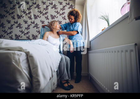 Home caregiver medicazione senior Foto Stock