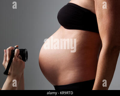 La pancia di una donna incinta essendo fotografato Foto Stock