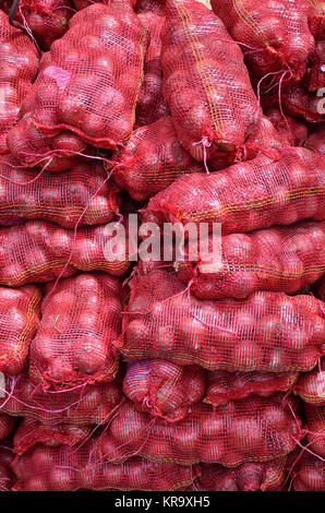 Sacs contenente cipolla grande impilati per la vendita Foto Stock