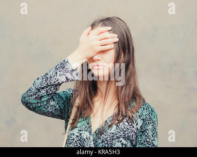 Facepalm ragazza sul muro grigio sfondo Foto Stock