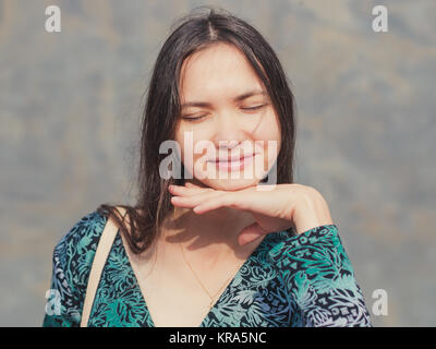 La ragazza con gli occhi chiusi e le mani sotto il mento Foto Stock