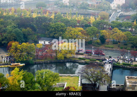 Il parco del Castello di Osaka antenna paesaggio autunnale con Gokurakubashi ponte sopra il fossato interno canal, imbarcazioni turistiche e una escursione in treno in una nebbiosa mattina. Foto Stock