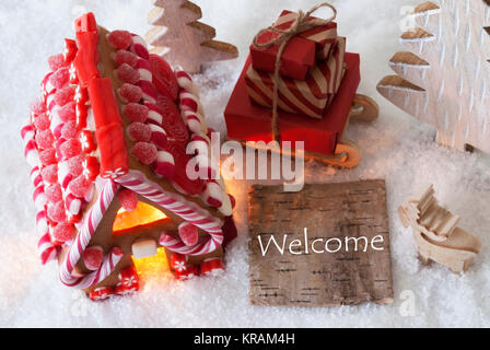 Etichetta con testo in inglese Benvenuti. Gingerbread House sulla neve con decorazione di Natale come gli alberi e alci. In slitta con i regali di Natale o presenta. Foto Stock