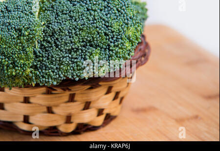 Close up sui broccoli freschi nel cestello solated su legno e sfondo bianco Foto Stock