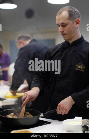 La Bielorussia Minsk, Marzo 21, 2017. Lezione aperta sulla cucina cucina francese.il cuoco prepara la carne.Lo chef prepara. Lo Chef guarda al cibo Foto Stock