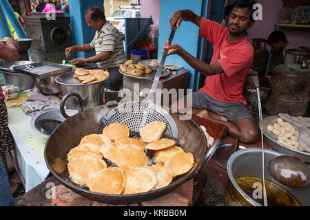 Un cuoco patate fritte Pani puri a un cibo hotel nella città di Lucknow, India Foto Stock