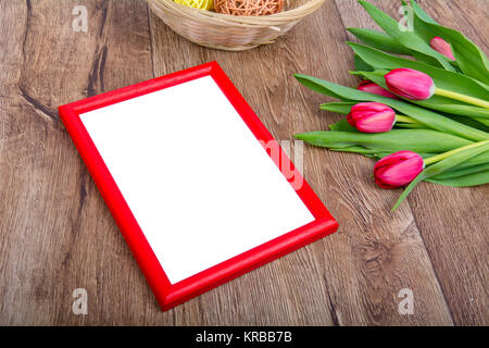 Red photo frame e tulipani su un tavolo di legno Foto Stock