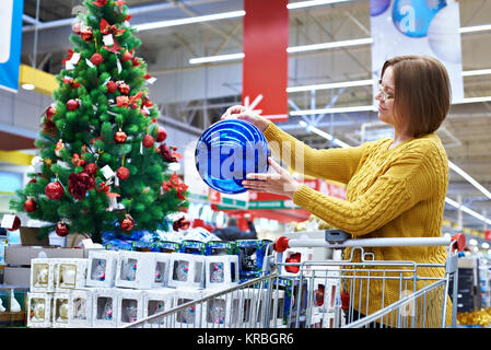 Donna felice al Natale in vendita in negozio Foto Stock