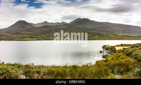 Carrountoohil e il Macgillycuddy Reeks della montagna salgono al di sopra del Lough Acoose in Glencar nella Contea di Kerry, Irlanda. Foto Stock