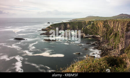 Un avvolgimento stretto sentiero conduce giù ripide scogliere a Dunquin Pier sulla rocciosa costa atlantica della penisola di Dingle in Irlanda la Contea di Kerry. Foto Stock