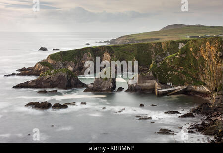 Un avvolgimento stretto sentiero conduce giù ripide scogliere a Dunquin Pier sulla rocciosa costa atlantica della penisola di Dingle in Irlanda la Contea di Kerry. Foto Stock