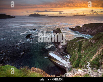 Tramonto a Dunquin Pier e le isole Blasket sulla rocciosa costa atlantica della penisola di Dingle in Irlanda la Contea di Kerry. Foto Stock