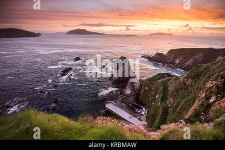 Tramonto a Dunquin Pier e le isole Blasket sulla rocciosa costa atlantica della penisola di Dingle in Irlanda la Contea di Kerry. Foto Stock