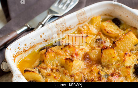 Pesce con patate e olive cotte in forno Foto Stock