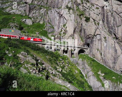 ANDERMATT, Svizzera Europa su luglio 2017: Express San Gottardo treno su Teufelsbruecke, Devil's ponte ferroviario e tunnel, alpi svizzere, alpine rocky. Foto Stock