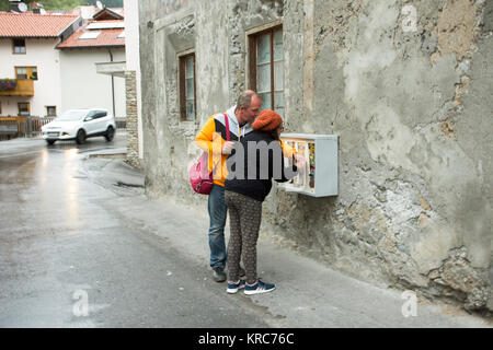 I viaggiatori persone giocare Gumball Machine - Capsule Toy stile europeo sulla parete a Pfunds villaggio nella serata del 2 settembre 2017, in Tirolo Austr Foto Stock