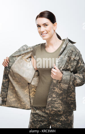 Felice felice donna indossando giacca mimetica Foto Stock