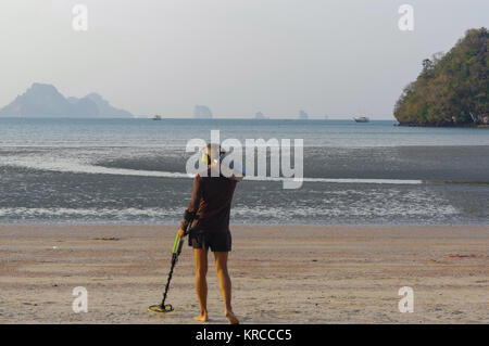 Il cacciatore di tesori con il rivelatore di metalli sulla spiaggia Foto Stock