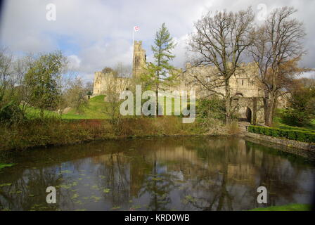 Una vista sull'acqua del castello di Prudhoe, Northumberland. L'edificio iniziò nel XII secolo come difesa contro gli invasori scozzesi, ed è stato aggiunto e restaurato nel corso dei secoli. Foto Stock