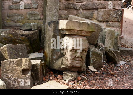 Una testa scolpita e vari blocchi di pietra al Black Country Museum, Dudley, West Midlands. Foto Stock