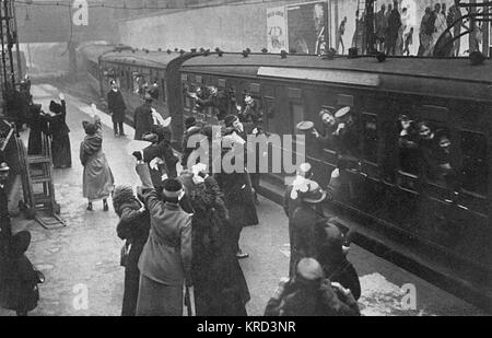 Le Truppe in arrivo (o eventualmente uscire) a un misterioso London rail station durante la Prima Guerra Mondiale. Numerose le donne e i familiari in piedi sulla piattaforma congedandosi e sui cartelloni visto sopra il treno sono manifesti di assunzione. Data: 1914 Foto Stock