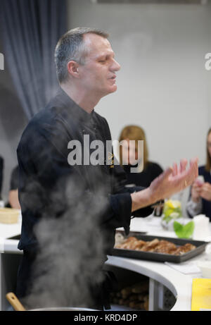 La Bielorussia Minsk, Marzo 21, 2017. Lezione aperta sulla cucina cucina francese.Lo chef prepara piatti, fumo sorge oltre le pentole.Lo chef prepara. Lo Chef guarda Foto Stock