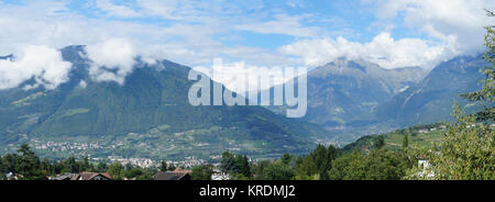 Panorama vom Talkessel Merano in Alto Adige, Italien; sonniger Sommertag, blauer Himmel und Gipfel in Wolken, Berge und Täler, Dörfer im Meraner Land Panoramica della conca di Merano in Alto Adige, Italia; giorno di sole in estate, cielo blu e picchi di nuvole, montagne e valli, villaggi nel paese di Merano Foto Stock