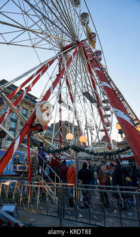 Una coda di persone che aspettano il loro turno su una ruota grande setup su George Square a Glasgow, per il periodo natalizio. Foto Stock