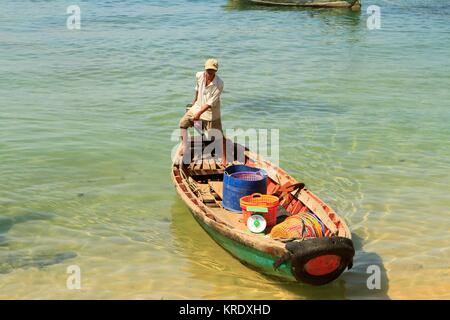 L'uomo motoring in con cestini di plastica e una scala di pesce a bordo, a Phu Quoc Island, Vietnam Foto Stock