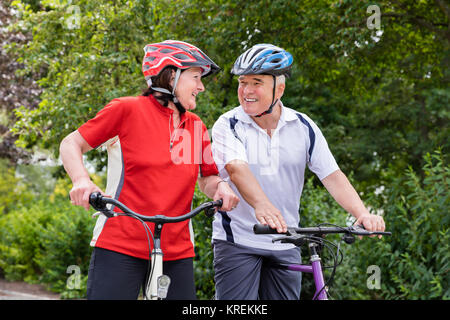 Coppia di anziani con le loro biciclette Foto Stock