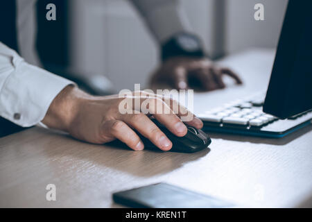 Mano sul mouse. Proprietario del computer. Il successo aziendale, di un contratto e di un importante documento di documenti cartacei o avvocato concetto. Uomo in ufficio Foto Stock