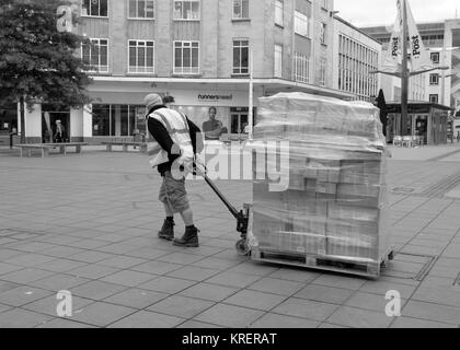 Giugno 2015 - Lavoro ragazzo con un pallet carico di magazzino in una strada pedonale per lo shopping nel centro di Bristol, - Broadmead Foto Stock