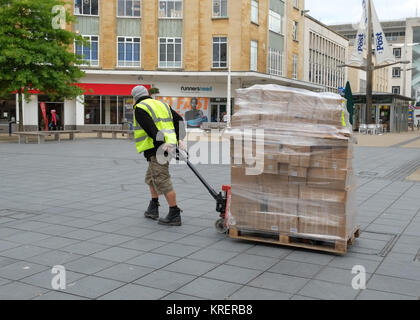 Giugno 2015 - Lavoro ragazzo con un pallet carico di magazzino in una strada pedonale per lo shopping nel centro di Bristol, - Broadmead Foto Stock