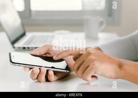 Closeup donna mano tramite telefono su spazio di lavoro in ufficio Foto Stock
